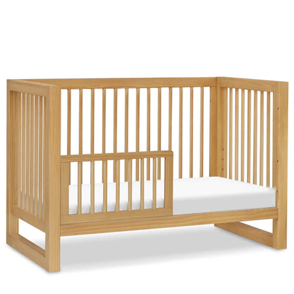 Side profile of honey finish Nantucket convertible crib, stylish and functional baby bed for nurseries in Eagle Rock, Pasadena, and Glendale.