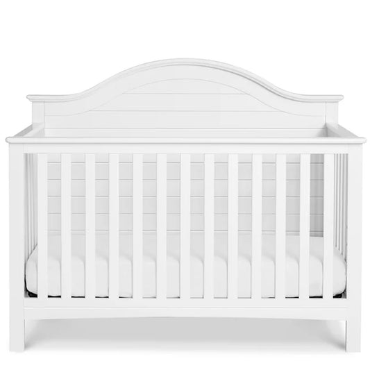 Elegant nursery crib with a shiplap-style planked headboard for a warm and inviting baby room