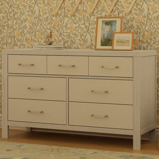 Elegant nursery dresser with fabric detailing and gold hardware